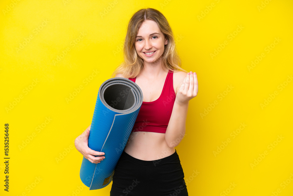 Young sport caucasian woman going to yoga classes while holding a mat isolated on yellow background making money gesture Young sport caucasian woman going to yoga classes while holding a mat isolated on yellow background making money gesture