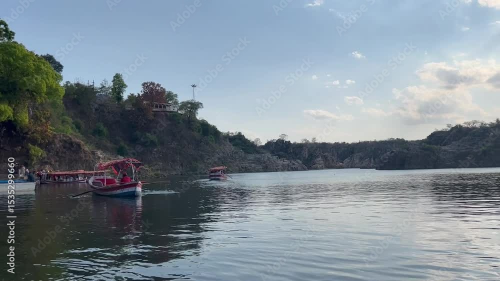 Tranquil boating scene at Bhedaghat during sunset, featuring serene waters, marble cliffs, and the golden glow of dusk. Tranquil boating scene at Bhedaghat during sunset, featuring serene waters, marble cliffs, and the golden glow of dusk.