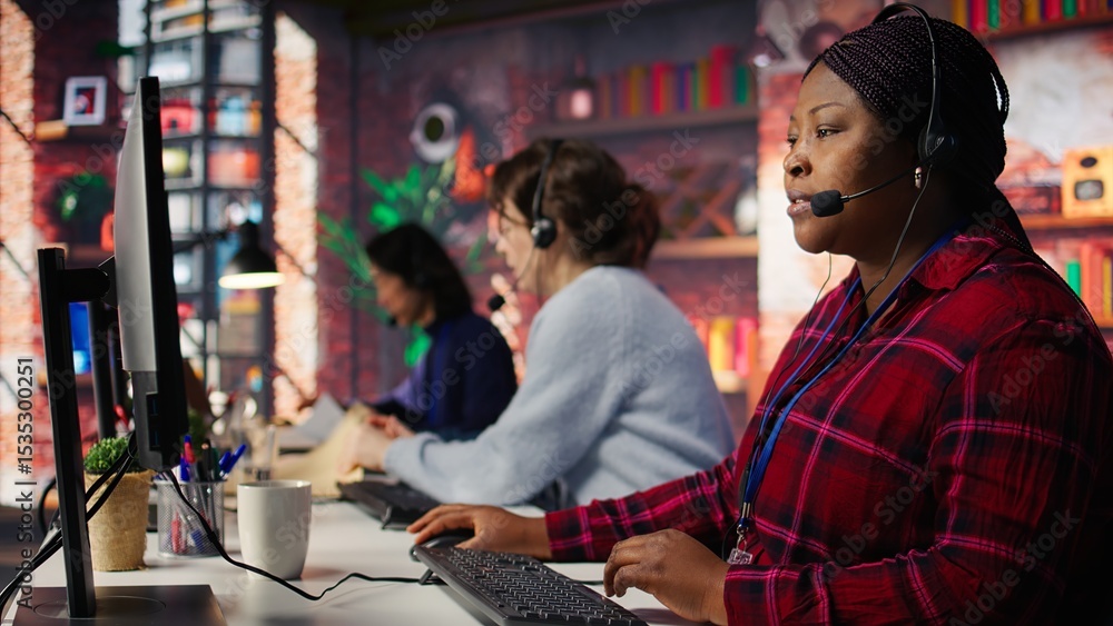 Obraz premium Happy call center agent providing step by step guidance to customers. Smiling customer center worker at PC desk walking clients through technical solutions during call, camera B