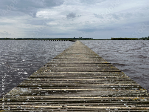 A long wooden walkway over a large lake