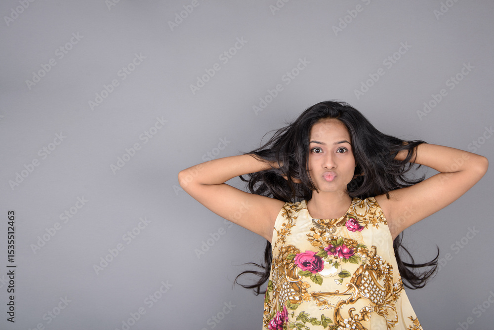 A charming young woman wearing a floral patterned top, black leggings and black heels, posing with jovial facial expressions and different emotions showcasing modern style, elegance. A charming young woman wearing a floral patterned top, black leggings and black heels, posing with jovial facial expressions and different emotions showcasing modern style, elegance.