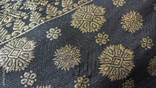 Black songket, traditional Malay woven textile with beautiful pattern made from golden sewing