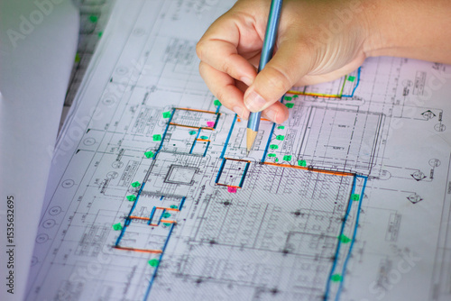 Civil Engineer Reviewing Detailed Building Layout with Hand on Blueprint