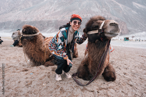 Canvas Print Smiling traveler poses with a majestic Bactrian camel in the stunning desert lan