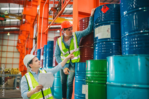 Industrial engineers inspect liquid storage drums in large-scale warehouse for export logistics, ensuring safety compliance, shipping standards, quality control of materials