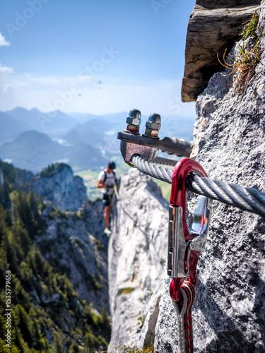 Climber On Fingersteig Via Ferrata Near Tegelberg: Adventurer Traversing Narrow Ridge With Harness And Helmet Against A Stunning Alpine Backdrop In Bavaria, Germany