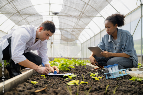 Practical agricultural studies of adolescent students, with scientists providing guidance, demonstrating hypotheses on soil sampling and data recording in greenhouse. Hands-on training in high school
