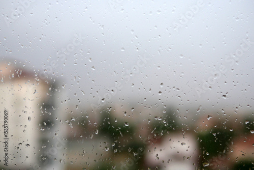 Raindrops falling on the balcony glass, raindrops sliding off the glass,