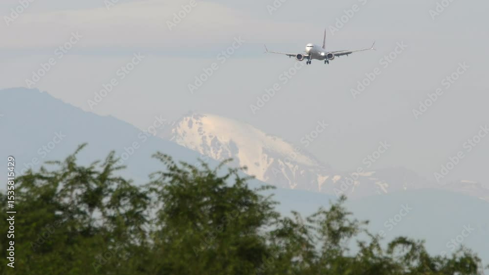 Jet aircraft approaching runway with scenic mountain backdrop. Aviation and travel theme Jet aircraft approaching runway with scenic mountain backdrop. Aviation and travel theme
