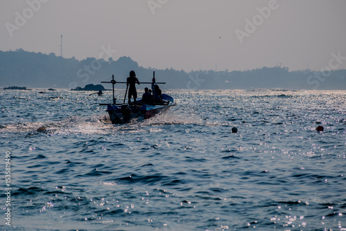 Foto Silhouetted Fishing Boat on the Ocean at Sunset near Polhena Beach, Matara, Sri