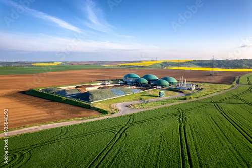 Moderne Biogasanlage zwischen Feldern in ländlicher Region