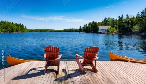two adirondack chairs sit on a wooden dock overlooking a blue muskoka lake nearby cabins line the shore a canoe is tied up and paddles rest inside capturing the essence of summer