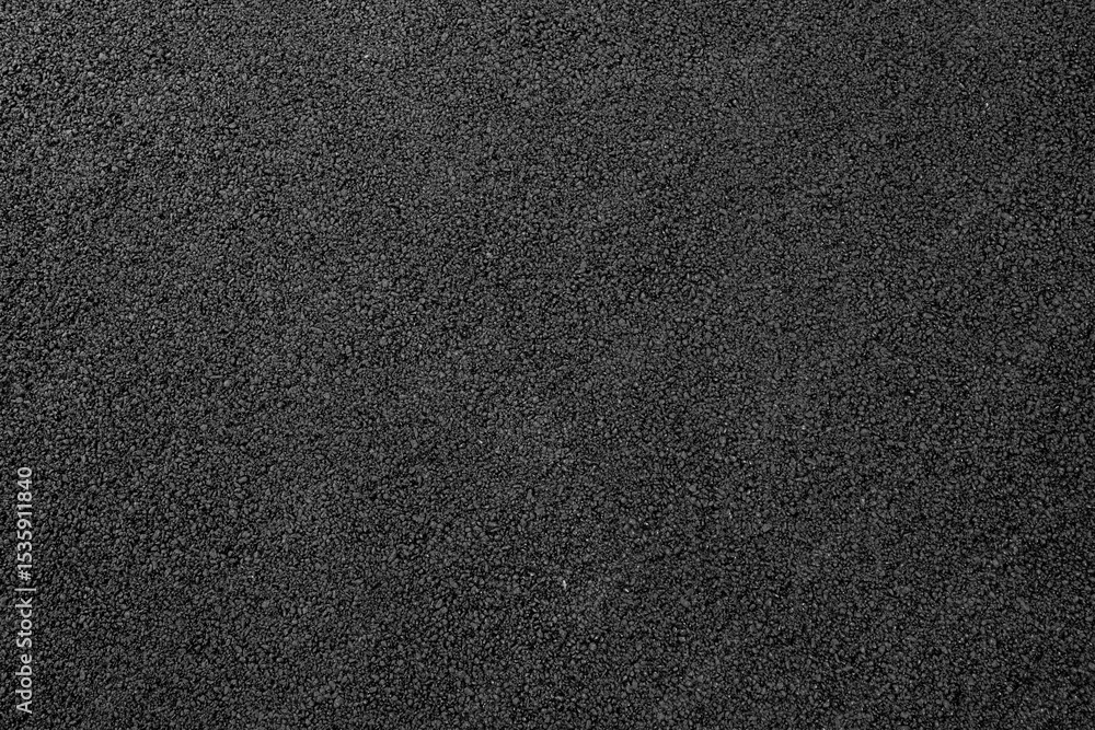 Close-up texture of smooth, freshly laid asphalt pavement with uniform dark gray color and fine