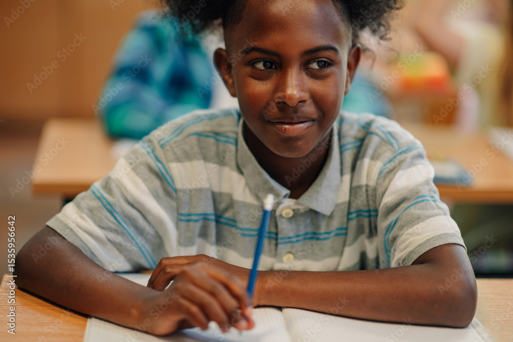 Elementary school student taking notes during class Elementary school student taking notes during class