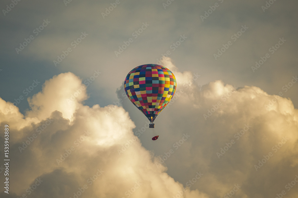 Fototapeta premium Colorful Hot Air Balloon Flying Above Clouds at Sunset Sky