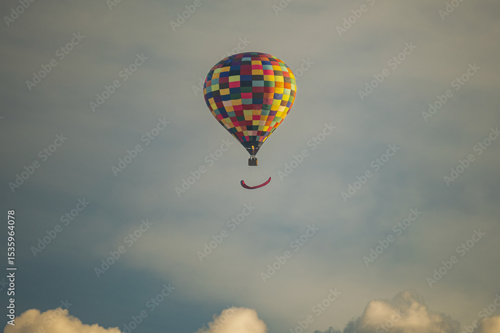 Fototapeta premium Colorful Hot Air Balloon Flying Above Clouds at Sunset Sky