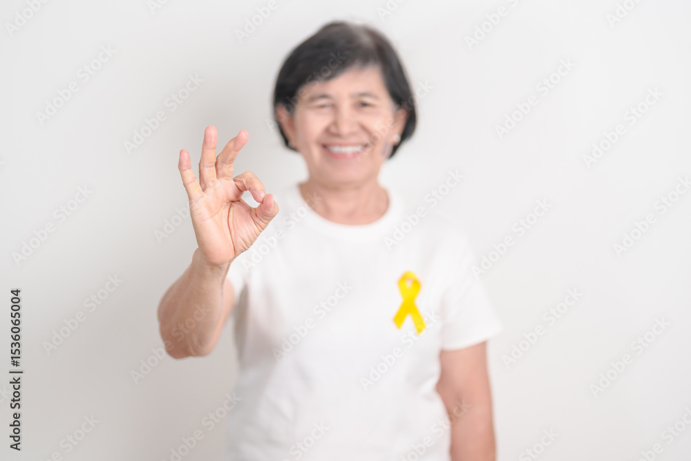 Elderly with Yellow Ribbon for concept of yellow September, Suicide prevention day, Childhood, July Sarcoma, bone cancer Awareness in children month, support survivor. Healthcare and World Cancer day Elderly with Yellow Ribbon for concept of yellow September, Suicide prevention day, Childhood, July Sarcoma, bone cancer Awareness in children month, support survivor. Healthcare and World Cancer day