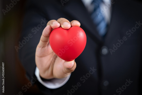 Businessman Holding Red Heart Shape Representing Love Care and Compassion