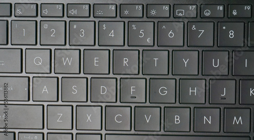 Close-up image of a black QWERTY keyboard, highlighting the number row and letter keys with clear white symbols on matte keycaps.