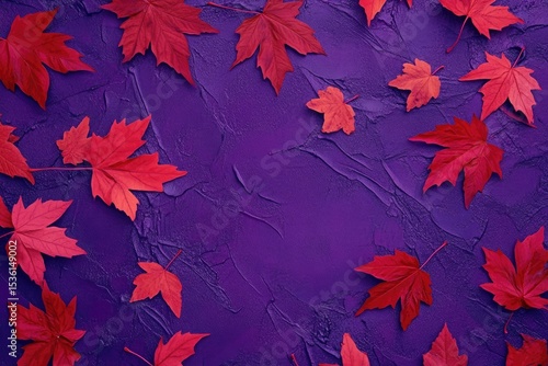 Autumnal maple leaves scattered on textured purple background