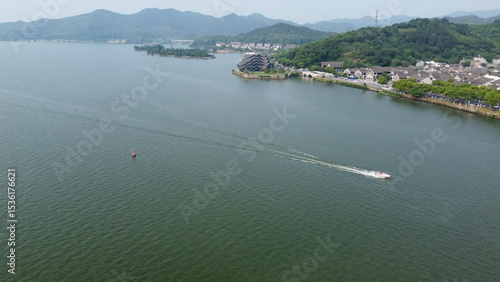 Aerial and ground views of Dongqian Lake and Art Center in Ningbo, China. Scenic lake, yachts, marina and iconic modern architecture surrounded by forested hills.