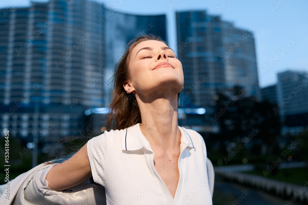 Fototapeta premium Confident businesswoman enjoying the moment in an urban setting, wearing a stylish outfit with a radiant smile, capturing empowerment and success.