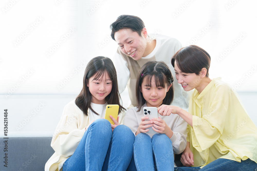 リビングでスマートフォンを使う親子 リビングでスマートフォンを使う親子