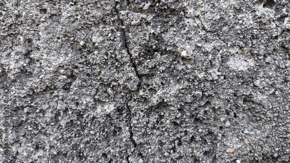 Fototapeta premium Grungy concrete wall texture with rough stone surface and vintage character, perfect for backgrounds, rustic overlays, or construction-themed visuals and natural decay effects.