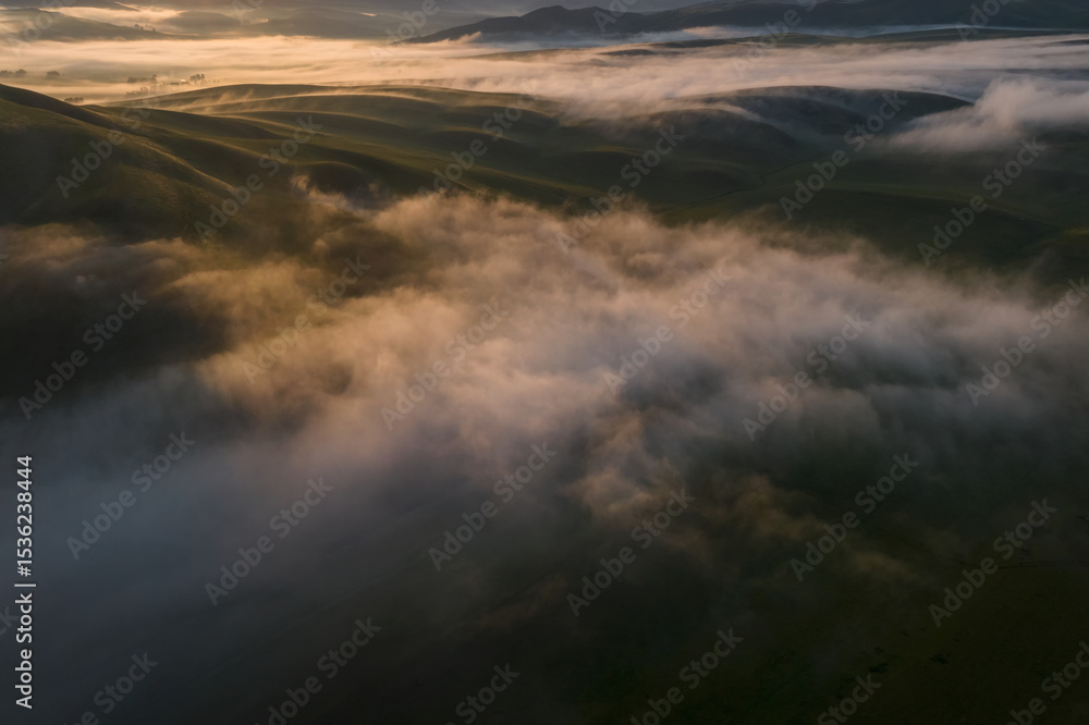 Obraz premium thick morning clouds over a hilly valley