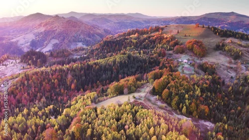 Ukraine, drone, flight in the Carpathians early autumn morning at sunrise near the city of Kosiv. Bright forests and frost of the night frost