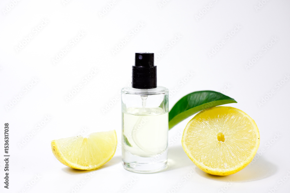 An elegant bottle of perfume with a delicate aroma with tropical lemon notes on a white background with ripe lemons. An original aroma of freshness. An elegant bottle of perfume with a delicate aroma with tropical lemon notes on a white background with ripe lemons. An original aroma of freshness.