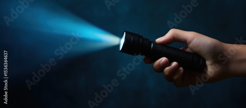 Illuminating the Darkness: A Hand Holding a Flashlight Beam