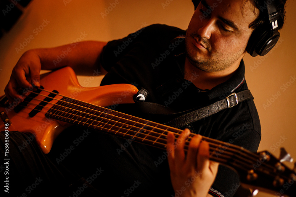 Obraz premium Músico tocando contrabaixo elétrico em estúdio de gravação / Musician playing electric bass guitar in recording studio