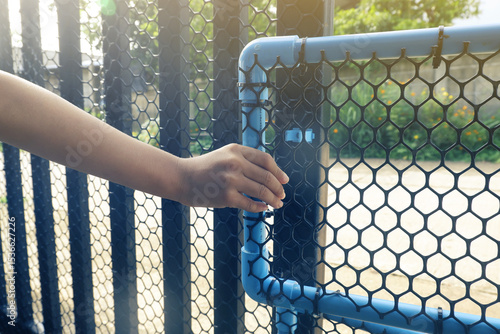 A child's hand is opening a small PVC door to block dogs.