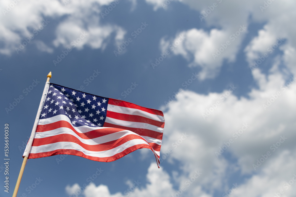 Fototapeta premium Hand holding the American flag for Independence Day - 4th of July. 