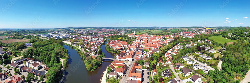 Fototapeta premium Luftaufnahme von Donauwörth mit roten Dächern, historischen Gebäuden und einem markanten Turm, eingebettet in eine grüne Landschaft. Die Stadt bietet eine charmante Kulisse.