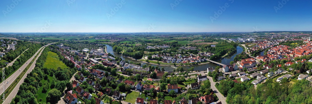 Fototapeta premium Luftaufnahme von Donauwörth mit roten Dächern, historischen Gebäuden und einem markanten Turm, eingebettet in eine grüne Landschaft. Die Stadt bietet eine charmante Kulisse.