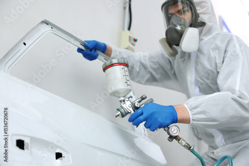 Photography Worker painting car door in body shop, selective focus