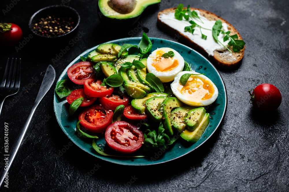 Healthy Breakfast with Avocado, Egg, and Tomato on a Plate Healthy Breakfast with Avocado, Egg, and Tomato on a Plate