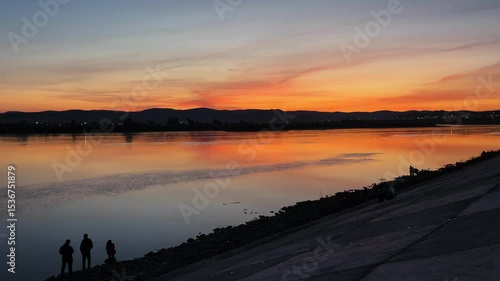 sunset over the river. people on the riverbank embankment