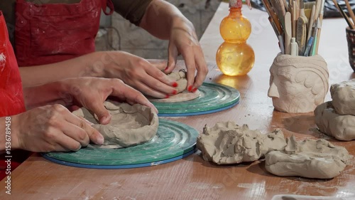 Dedicated potters skillfully shaping clay bowls in a vibrant ceramics studio