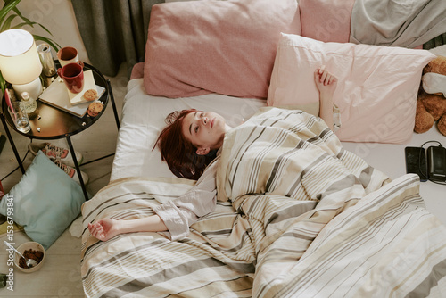 Tableau sur toile Person lying in bed while surrounded by soft blankets and pillows next to person