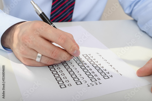 фотографія A man completes a test, marking answers a b c or d