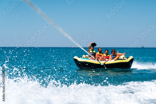 A group of friend having fun behind a speedboad on the sea