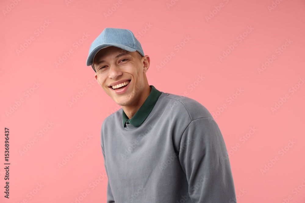 Young man in stylish baseball hat on pink background Young man in stylish baseball hat on pink background