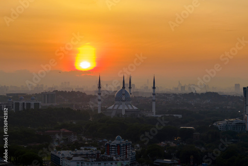 The mosque stands tall against the backdrop of a city