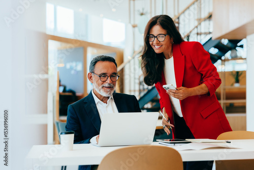 Behang Two senior business professionals working together in an office environment