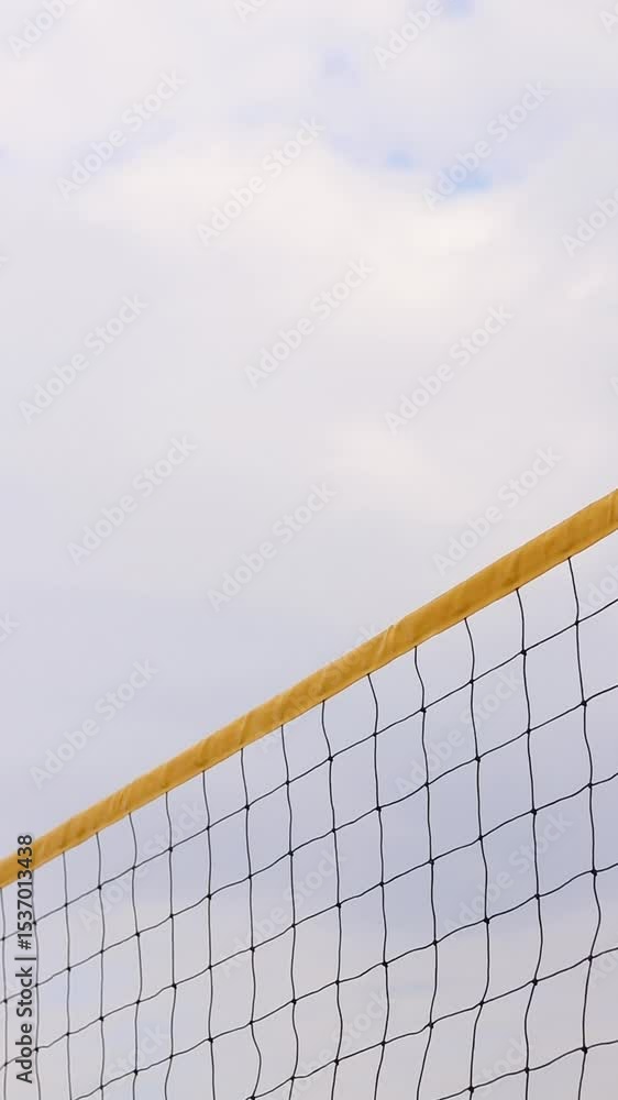 Beach volleyball net close-up. Fragment of a volleyball net on the beach against a cloudy sky. Sport, beach volleyball. Active recreation concept. Sports ground. Active summer games. Sports equipment Beach volleyball net close-up. Fragment of a volleyball net on the beach against a cloudy sky. Sport, beach volleyball. Active recreation concept. Sports ground. Active summer games. Sports equipment