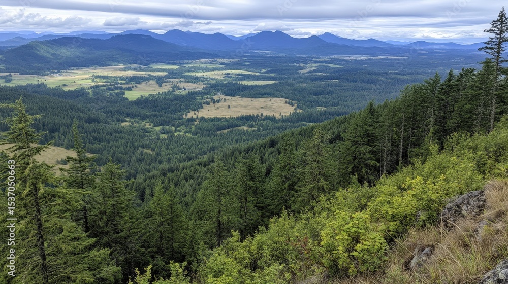 Fototapeta premium Serene Mountain Landscape Overlooking Lush Green Valley Surrounded by Majestic Hills and Dramatic Cloudy Sky in Scenic Nature Environment
