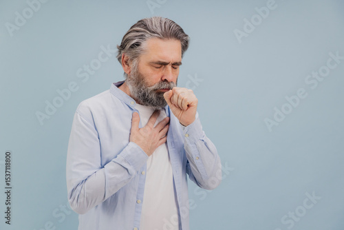 Photos Senior man coughing and holding his chest suffering from illness